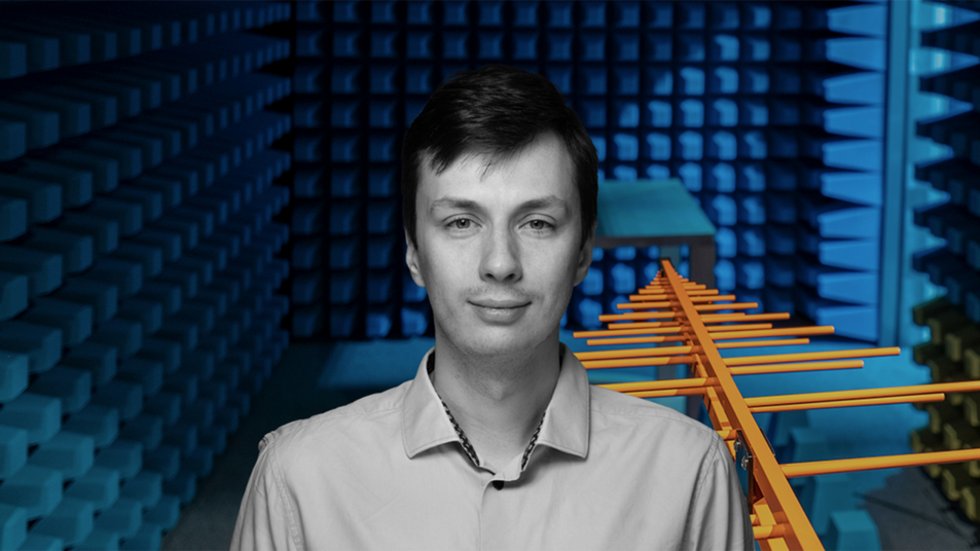 mgr inż. Maciej Ślot against the background of an aerial and a soundproof room
