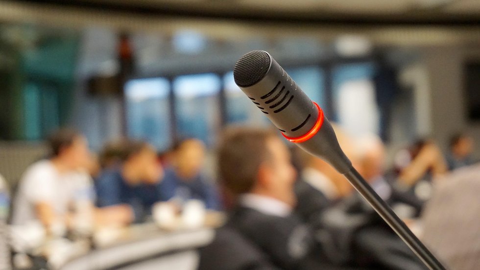 A decoartive element: a microphone and a blurred auditorium background